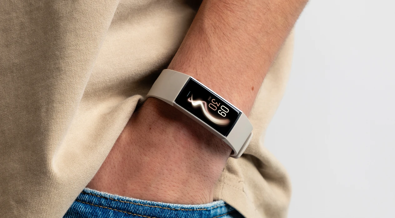 A person wearing a smartwatch displays the time and steps on the screen, with one hand in their jeans pocket, against a plain white background.