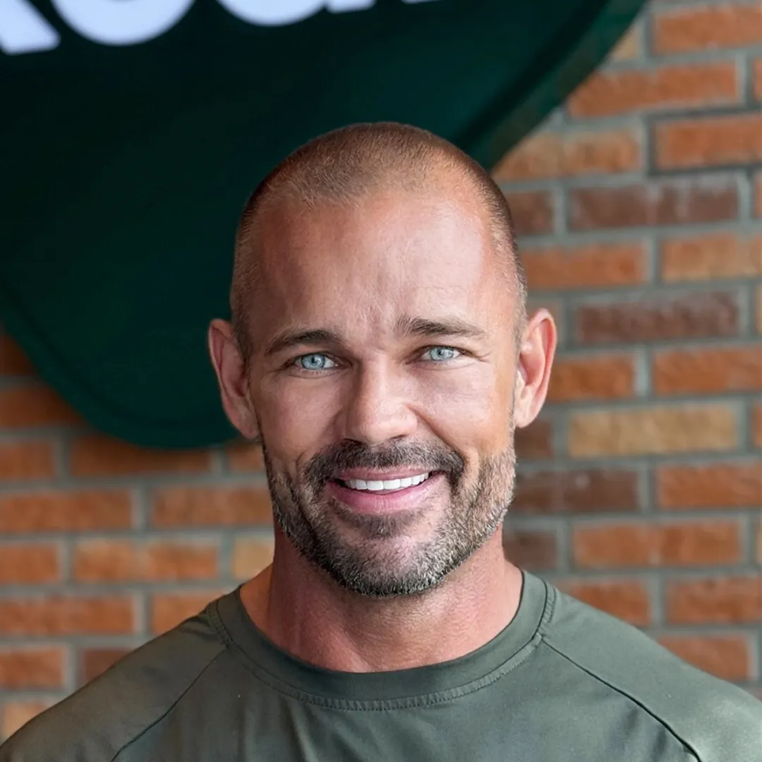 Andreas L Borgmann, Kcal Founder and CEO, standing in the Kcal Restaurant in Motor City, Dubai, wearing a green t-shirt.