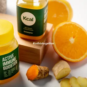 A bottle of Kcal's Super Shot to help boost immunity is placed on a wooden block with sliced orange and ginger.