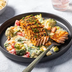 A baked salmon fillet meal on a grey plate.