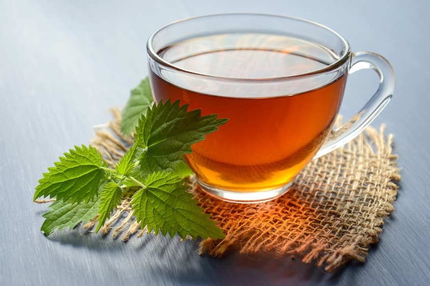 Glass cup of green tea on a woven coaster