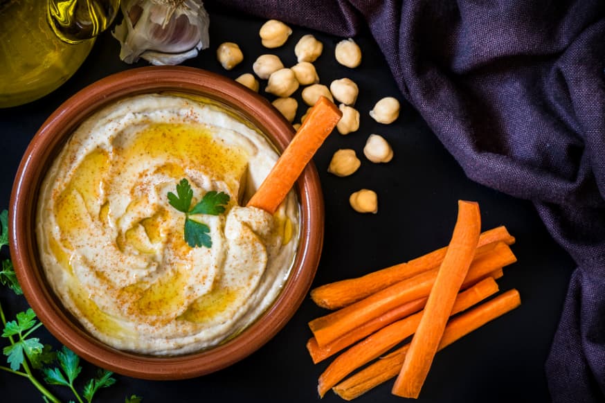 Bowl of hummus with carrot sticks as a healthy weight loss snack