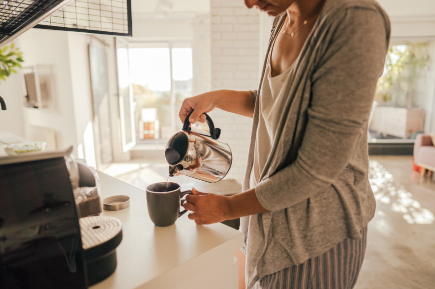 Woman making a fresh morning coffee in the kitchen. 
