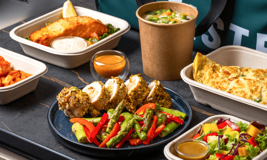 A colorful assortment of whole, natural foods including fruits, vegetables, grains, and nuts arranged on a table.