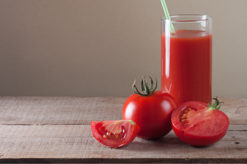 Glass of tomato juice and fresh tomatoes